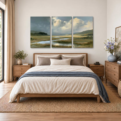 A winding stream through an open meadow beneath large sunlit clouds 3 piece canvas wall art styled in an interior