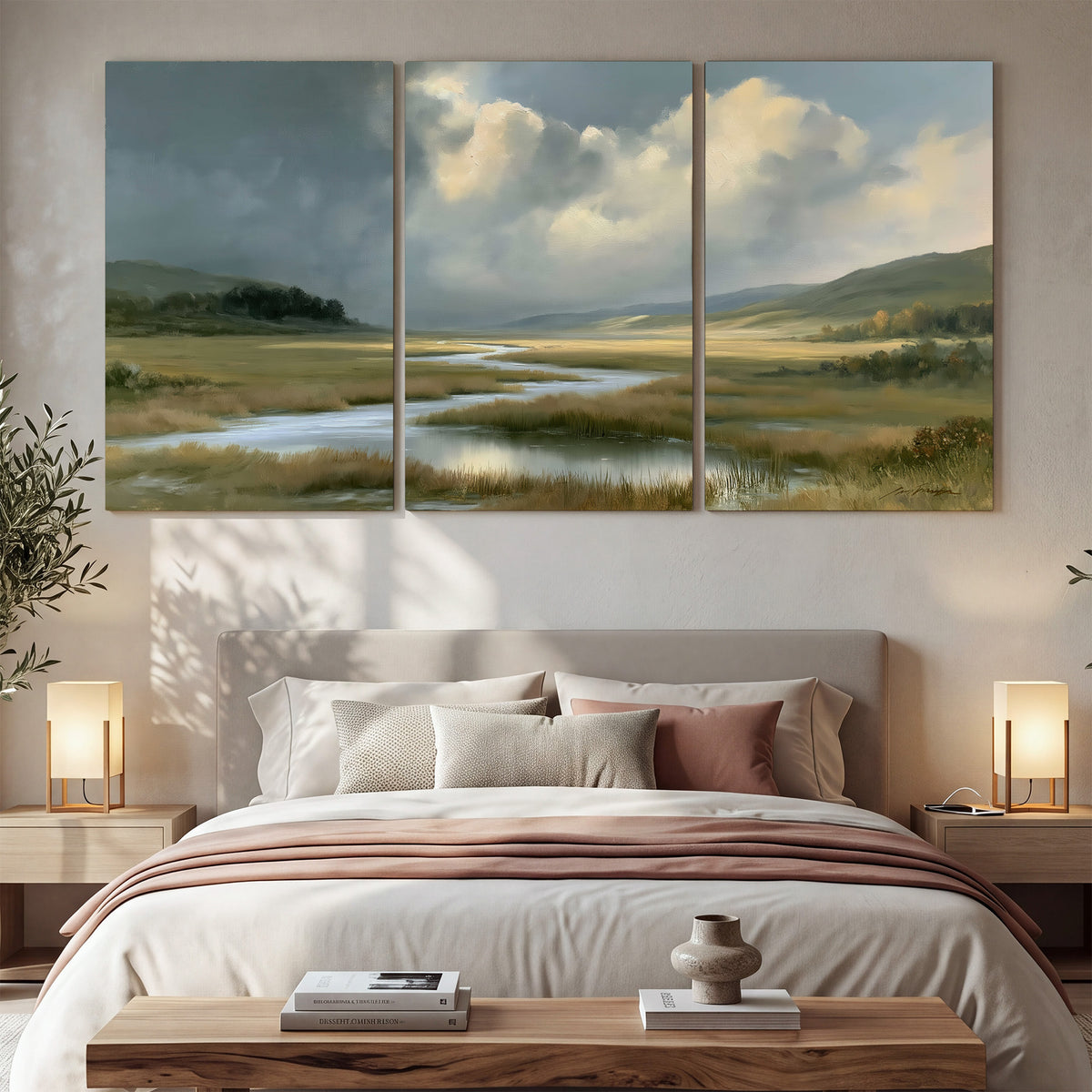 A winding stream through an open meadow beneath large sunlit clouds 3 piece canvas wall art displayed in a bedroom