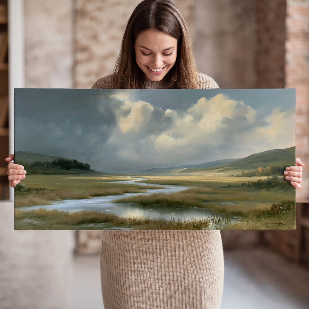 A winding stream through an open meadow beneath large sunlit clouds single canvas wall art held in hands
