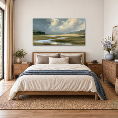 A winding stream through an open meadow beneath large sunlit clouds single canvas wall art styled in an interior