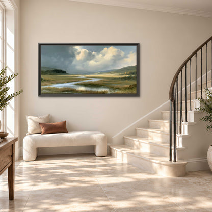 A winding stream through an open meadow beneath large sunlit clouds single framed canvas wall art styled in an interior