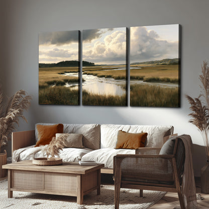 Pools of still water reflecting a dramatic cloud-filled sky across a golden marsh 3 piece canvas wall art displayed in a rustic living room