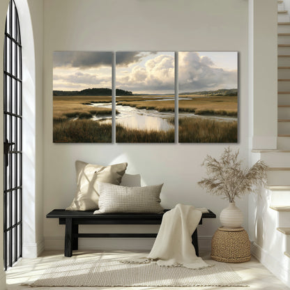 Pools of still water reflecting a dramatic cloud-filled sky across a golden marsh 3 piece canvas wall art displayed in a entryway