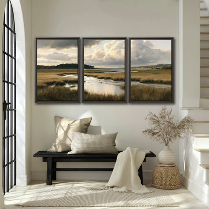 Pools of still water reflecting a dramatic cloud-filled sky across a golden marsh 3 piece framed canvas wall art displayed in a entryway