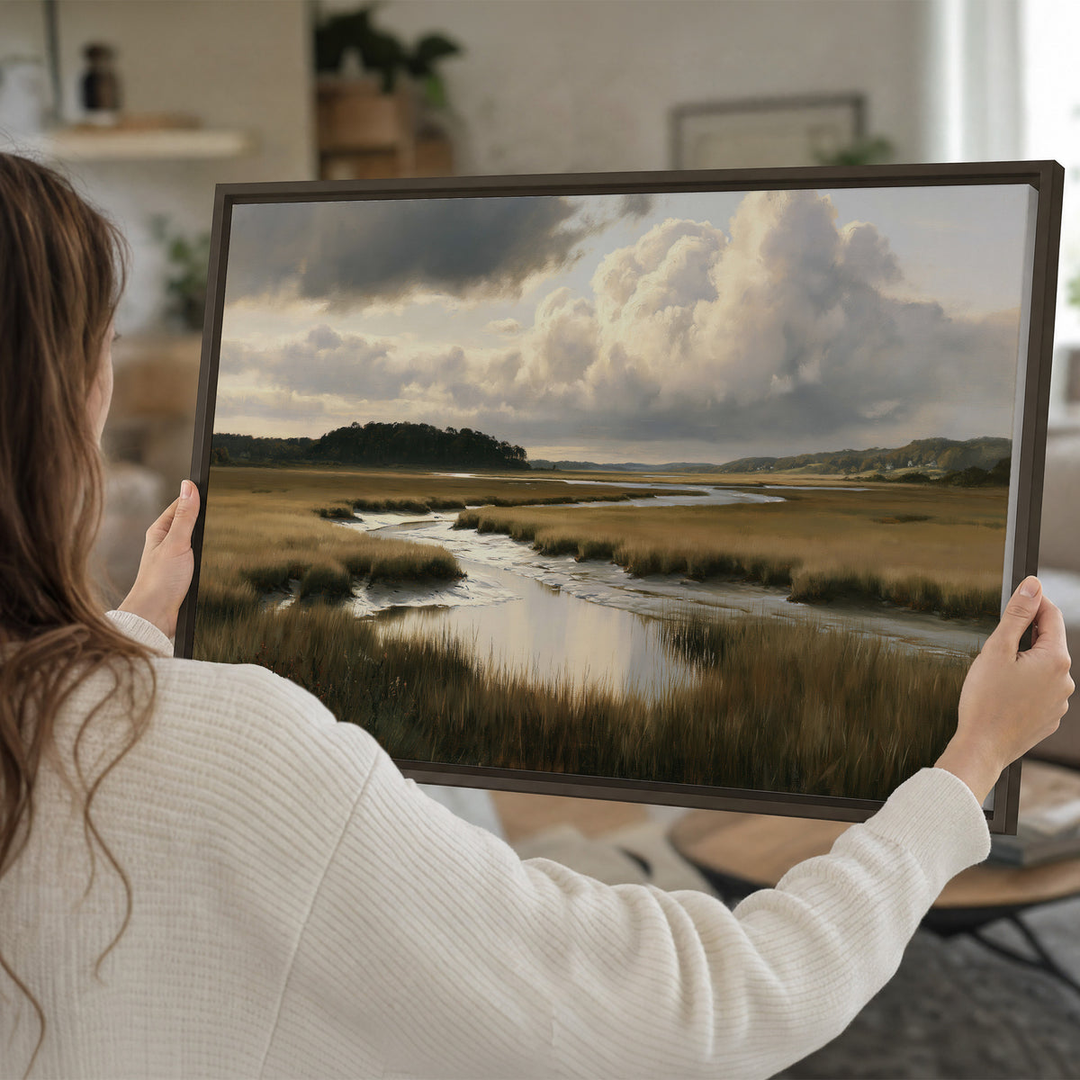 Pools of still water reflecting a dramatic cloud-filled sky across a golden marsh single framed canvas wall art held in hands
