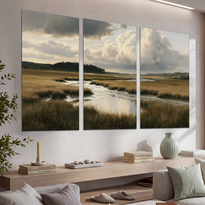 Pools of still water reflecting a dramatic cloud-filled sky across a golden marsh set of 3 poster prints displayed in a console