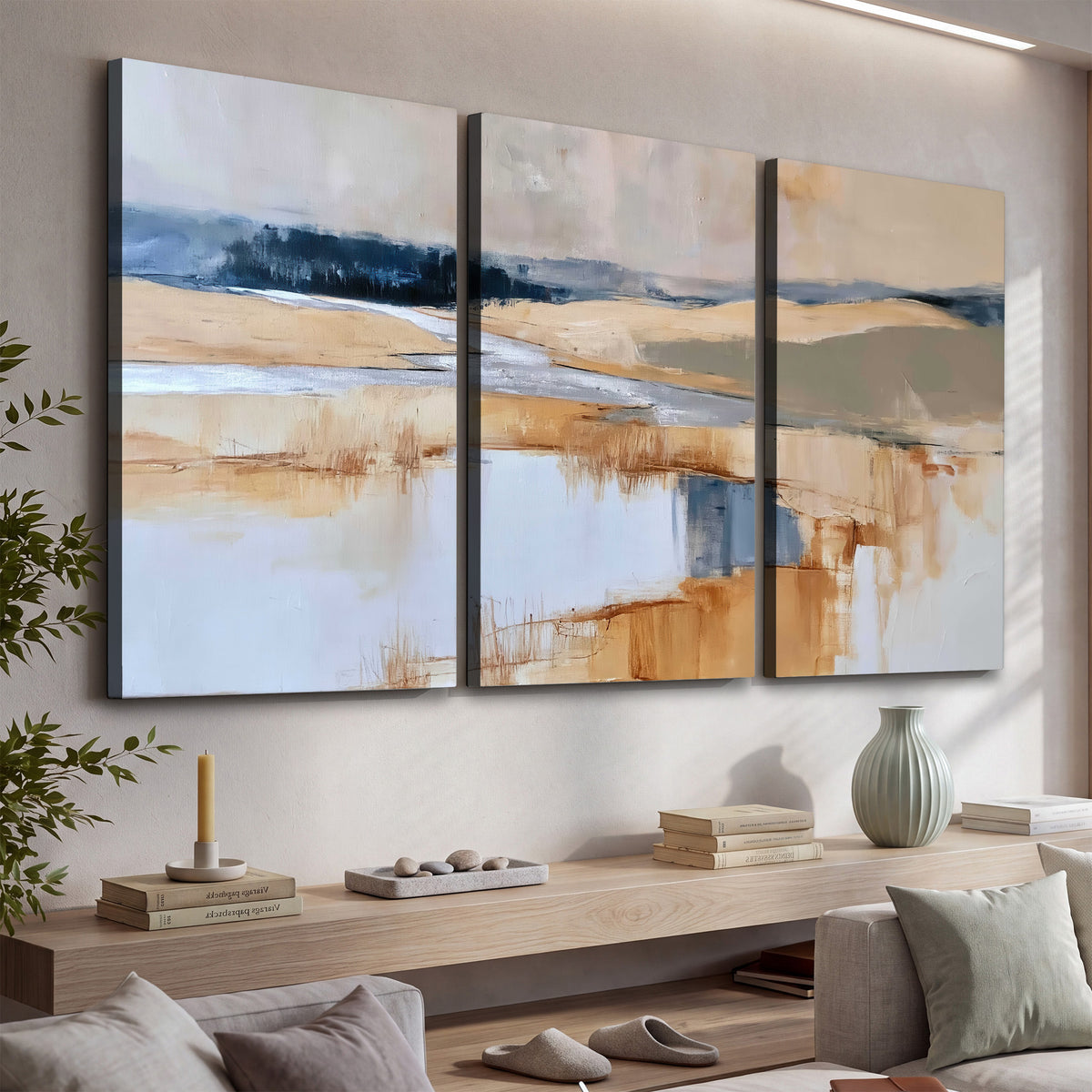 Soft horizontal bands of blue, ochre and ivory suggesting a reflected marsh landscape 3 piece canvas wall art displayed in a console