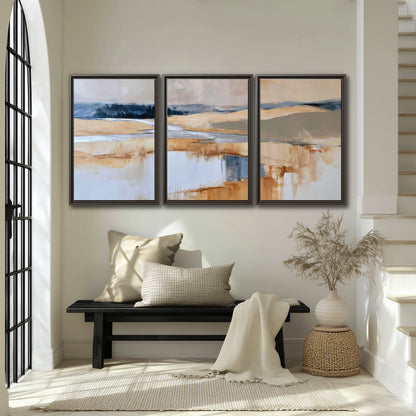 Soft horizontal bands of blue, ochre and ivory suggesting a reflected marsh landscape 3 piece framed canvas wall art displayed in a entryway