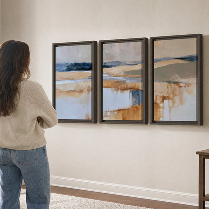 Soft horizontal bands of blue, ochre and ivory suggesting a reflected marsh landscape 3 piece framed canvas wall art three panel arrangement on a wall