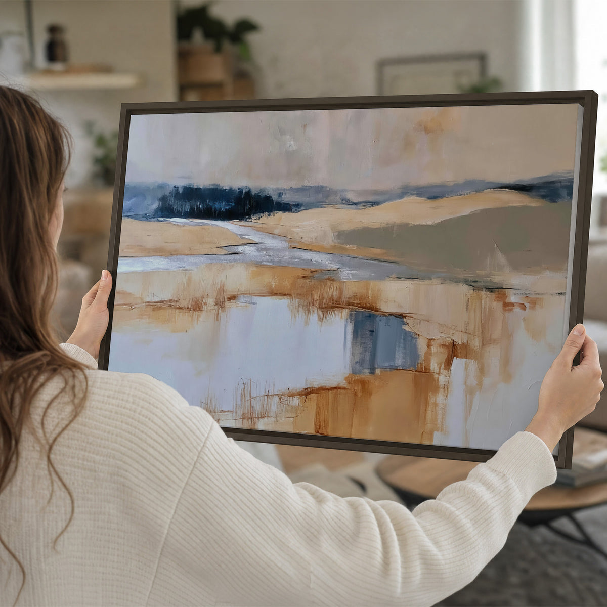 Soft horizontal bands of blue, ochre and ivory suggesting a reflected marsh landscape single framed canvas wall art held in hands