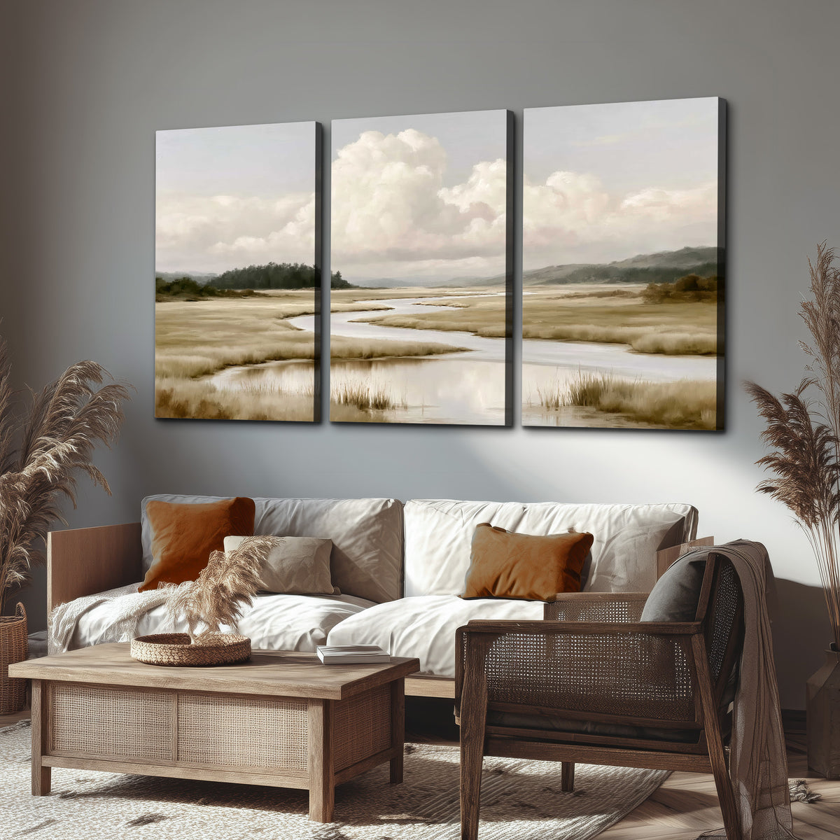 A pale winding waterway crossing quiet wetlands beneath billowing white clouds 3 piece canvas wall art displayed in a rustic living room