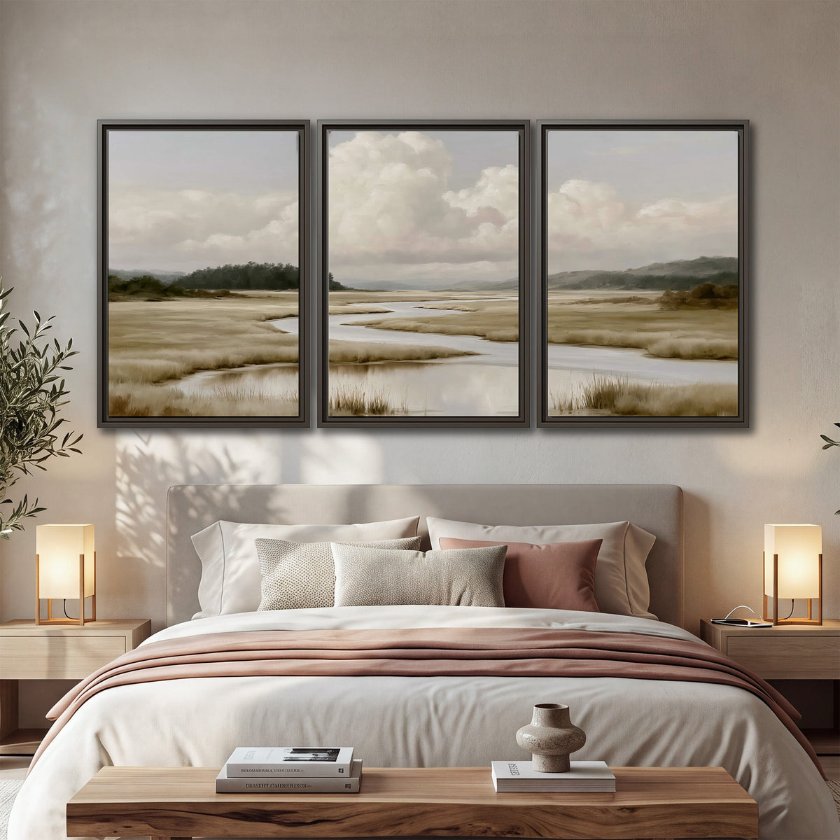 A pale winding waterway crossing quiet wetlands beneath billowing white clouds 3 piece framed canvas wall art displayed in a bedroom