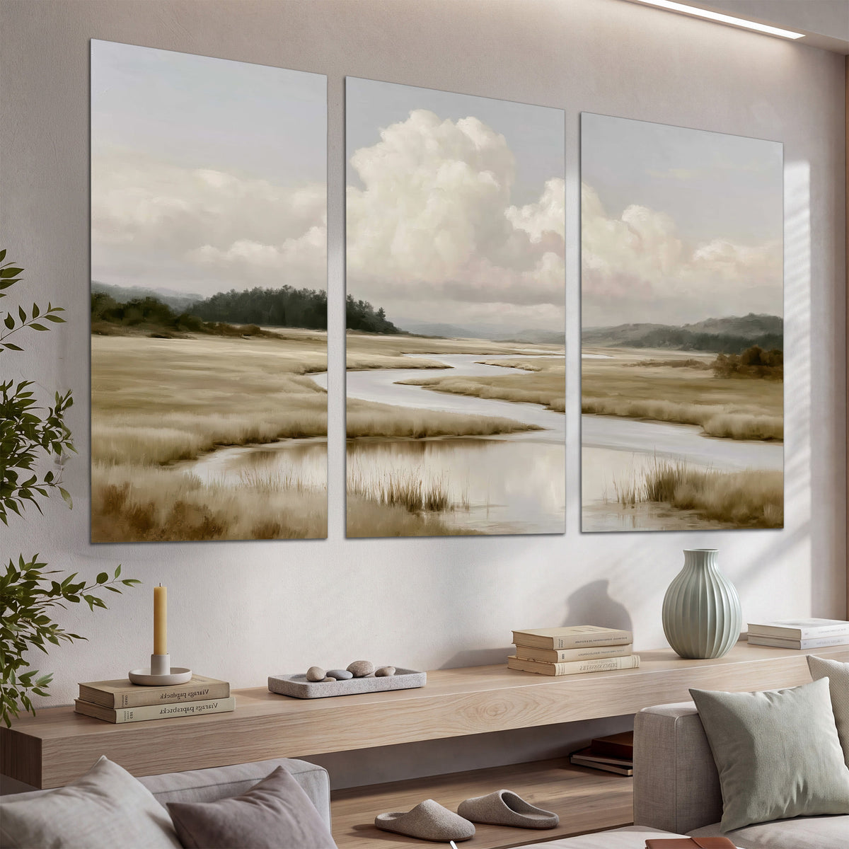 A pale winding waterway crossing quiet wetlands beneath billowing white clouds set of 3 poster prints displayed in a console