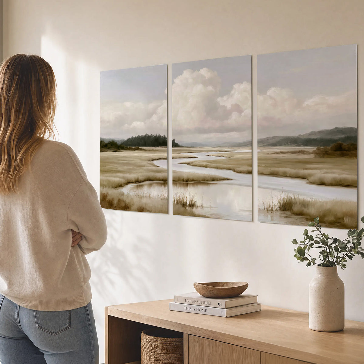 A pale winding waterway crossing quiet wetlands beneath billowing white clouds set of 3 poster prints three panel arrangement on a wall