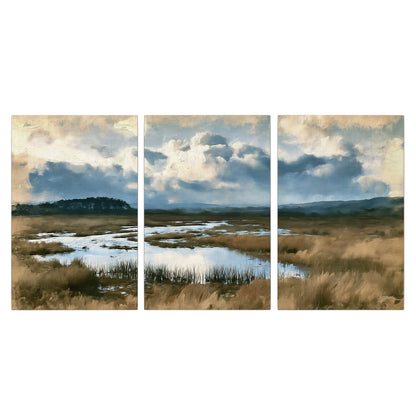 A wide open marsh with blue water and warm grasses beneath layered clouds 3 piece canvas wall art viewed straight on