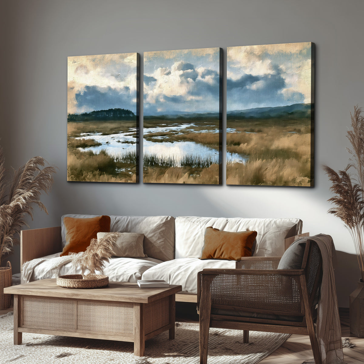 A wide open marsh with blue water and warm grasses beneath layered clouds 3 piece canvas wall art displayed in a rustic living room