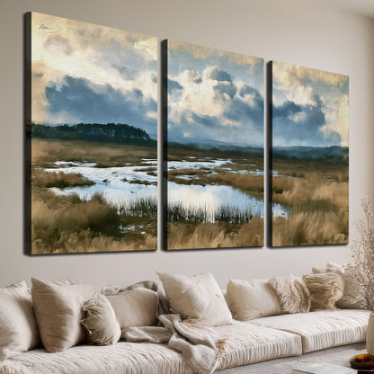 A wide open marsh with blue water and warm grasses beneath layered clouds 3 piece canvas wall art room and product view