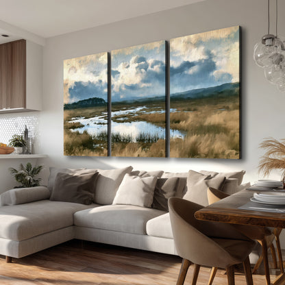 A wide open marsh with blue water and warm grasses beneath layered clouds 3 piece canvas wall art room and product view