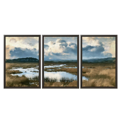 A wide open marsh with blue water and warm grasses beneath layered clouds 3 piece framed canvas wall art viewed straight on