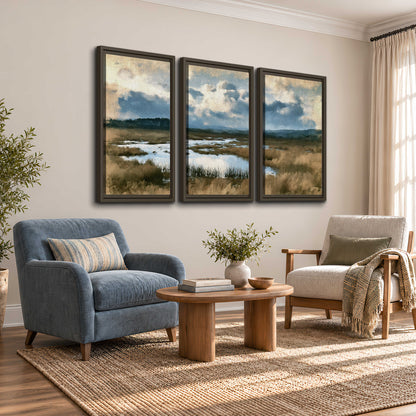 A wide open marsh with blue water and warm grasses beneath layered clouds 3 piece framed canvas wall art styled in an interior
