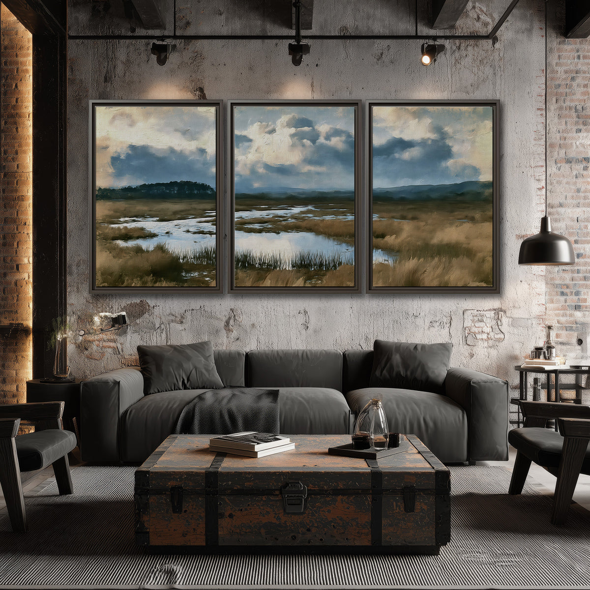 A wide open marsh with blue water and warm grasses beneath layered clouds 3 piece framed canvas wall art displayed in a industrial room