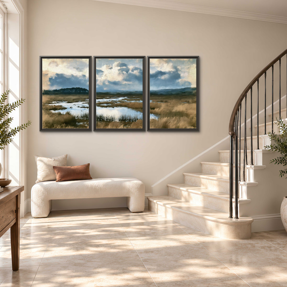 A wide open marsh with blue water and warm grasses beneath layered clouds 3 piece framed canvas wall art styled in an interior
