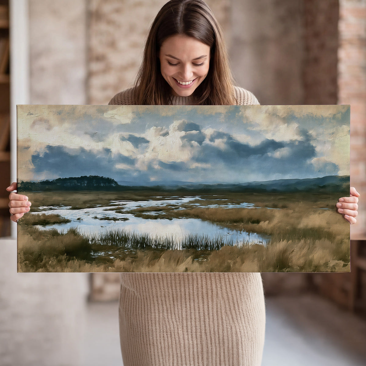 A wide open marsh with blue water and warm grasses beneath layered clouds single canvas wall art held in hands