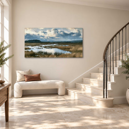 A wide open marsh with blue water and warm grasses beneath layered clouds single canvas wall art styled in an interior