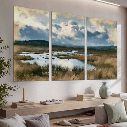 A wide open marsh with blue water and warm grasses beneath layered clouds set of 3 poster prints displayed in a console