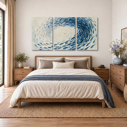 A circular school of blue fish flowing around a pale open center 3 piece canvas wall art styled in an interior