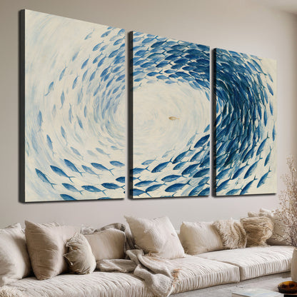A circular school of blue fish flowing around a pale open center 3 piece canvas wall art room and product view