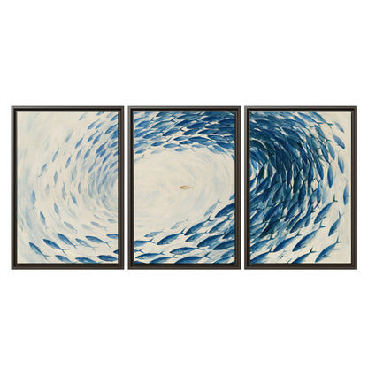 A circular school of blue fish flowing around a pale open center 3 piece framed canvas wall art viewed straight on
