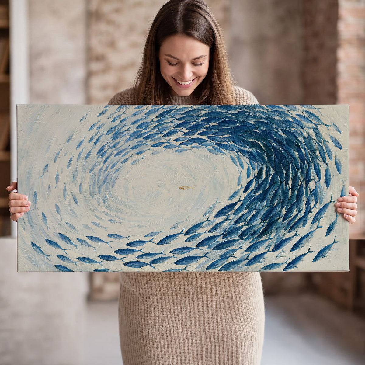 A circular school of blue fish flowing around a pale open center single canvas wall art held in hands
