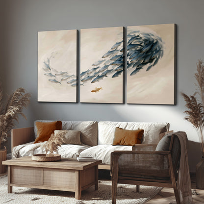 A sweeping school of small gray fish curving across a pale neutral background 3 piece canvas wall art displayed in a rustic living room