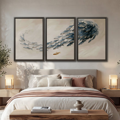 A sweeping school of small gray fish curving across a pale neutral background 3 piece framed canvas wall art displayed in a bedroom