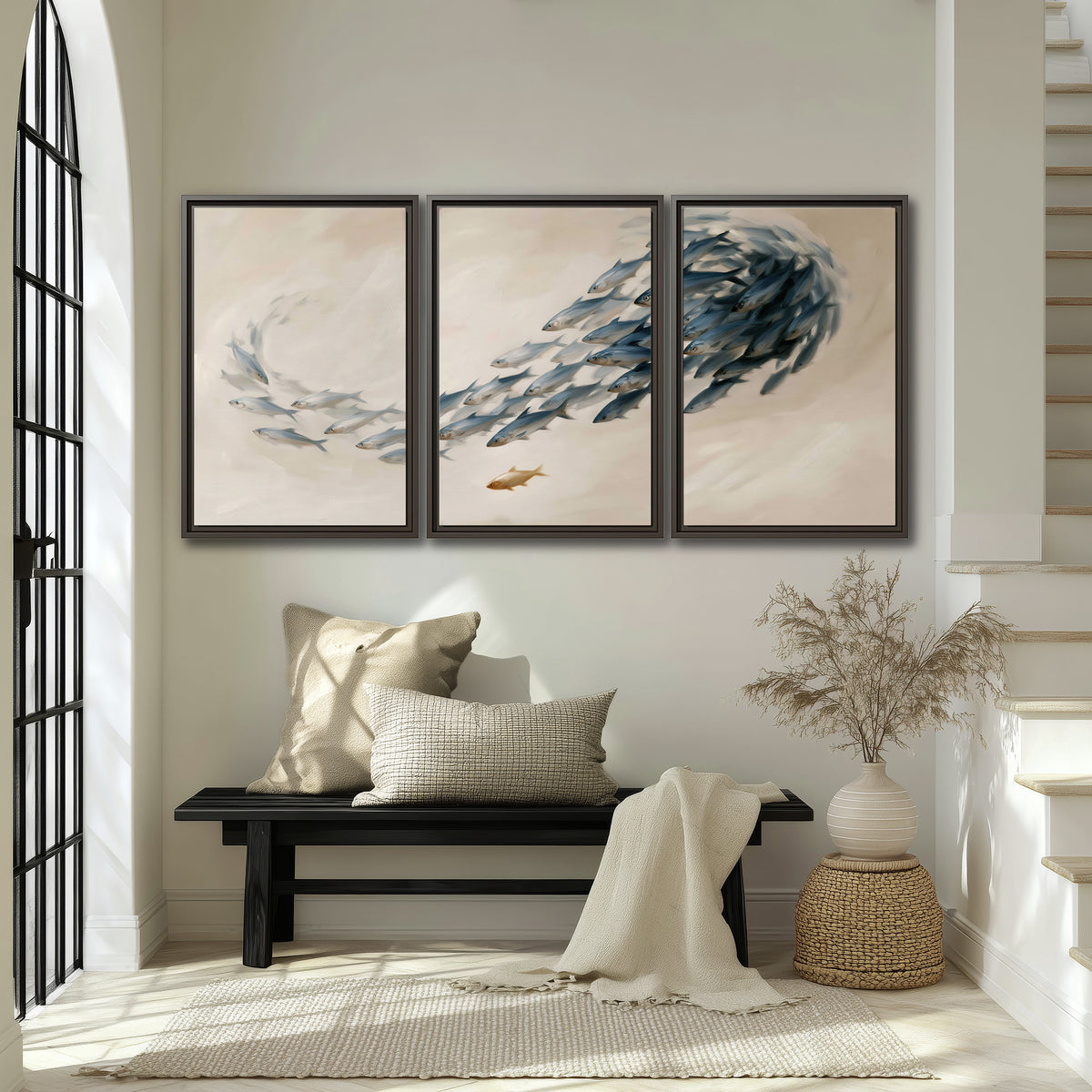 A sweeping school of small gray fish curving across a pale neutral background 3 piece framed canvas wall art displayed in a entryway