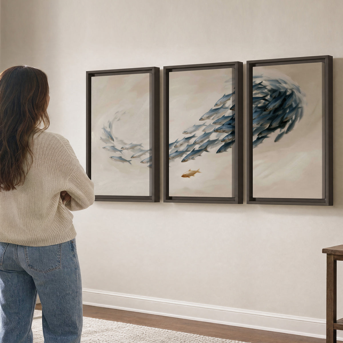 A sweeping school of small gray fish curving across a pale neutral background 3 piece framed canvas wall art three panel arrangement on a wall