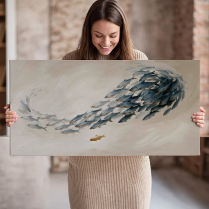 A sweeping school of small gray fish curving across a pale neutral background single canvas wall art held in hands