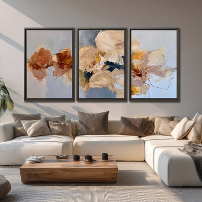 Loose ivory and ochre flower forms layered over a pale blue painterly background 3 piece framed canvas wall art displayed in a living room