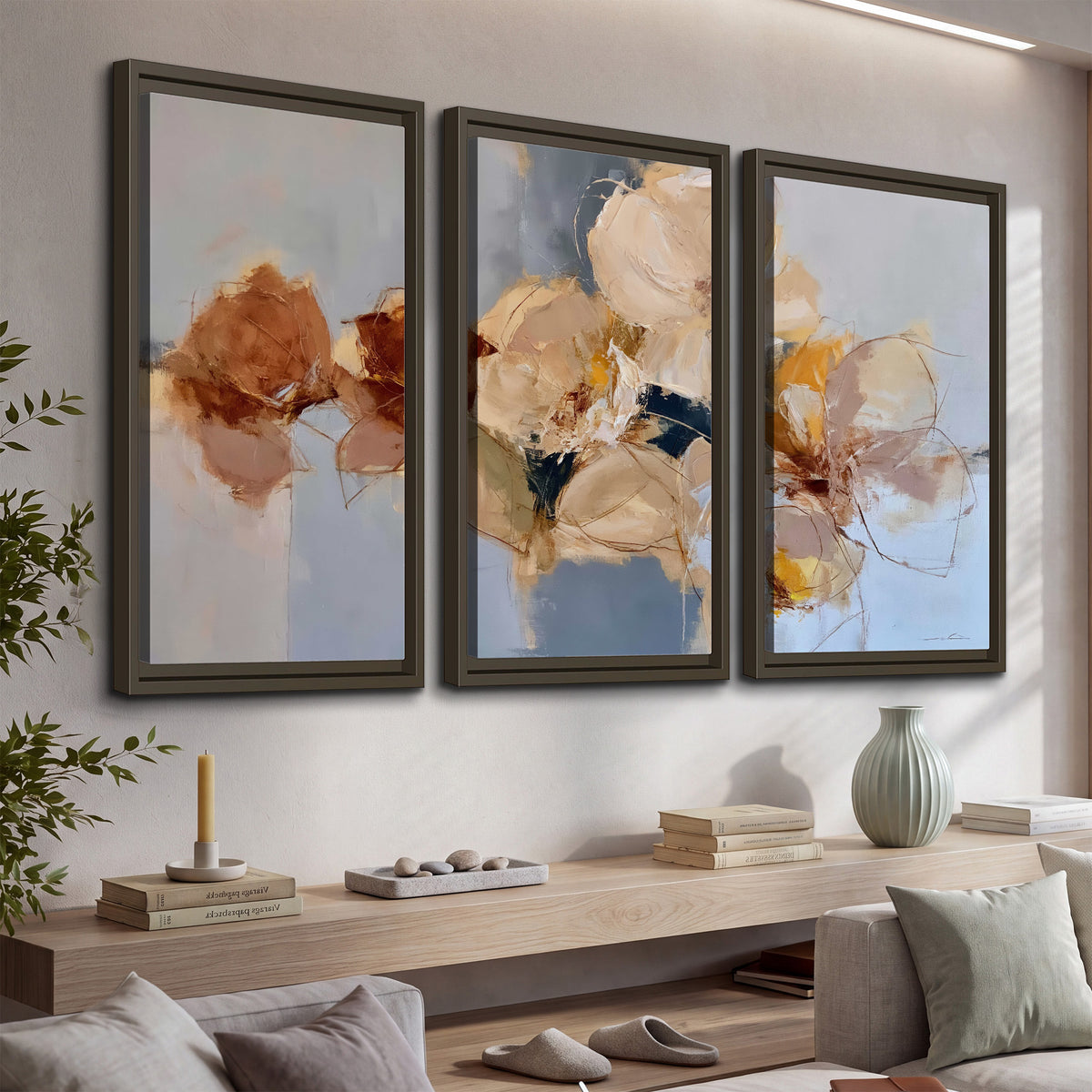 Loose ivory and ochre flower forms layered over a pale blue painterly background 3 piece framed canvas wall art displayed in a console