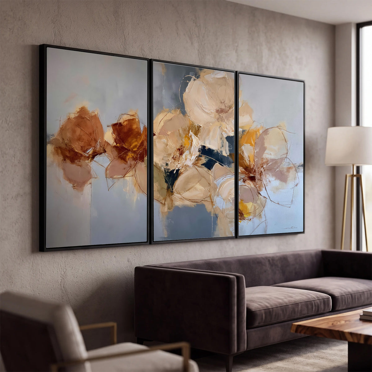 Loose ivory and ochre flower forms layered over a pale blue painterly background 3 piece framed canvas wall art displayed in a modern living room