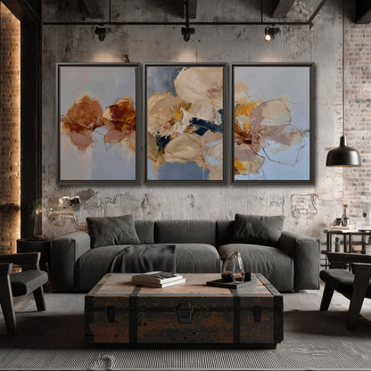 Loose ivory and ochre flower forms layered over a pale blue painterly background 3 piece framed canvas wall art displayed in a industrial room