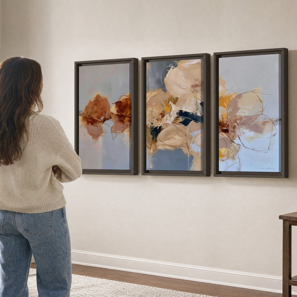 Loose ivory and ochre flower forms layered over a pale blue painterly background 3 piece framed canvas wall art three panel arrangement on a wall
