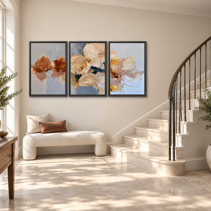 Loose ivory and ochre flower forms layered over a pale blue painterly background 3 piece framed canvas wall art styled in an interior