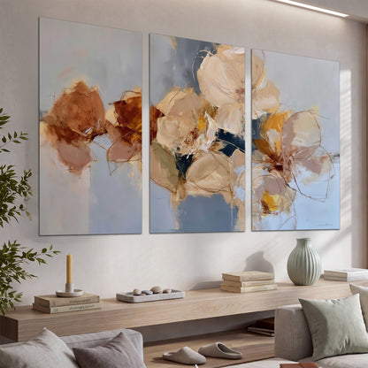 Loose ivory and ochre flower forms layered over a pale blue painterly background set of 3 poster prints displayed in a console