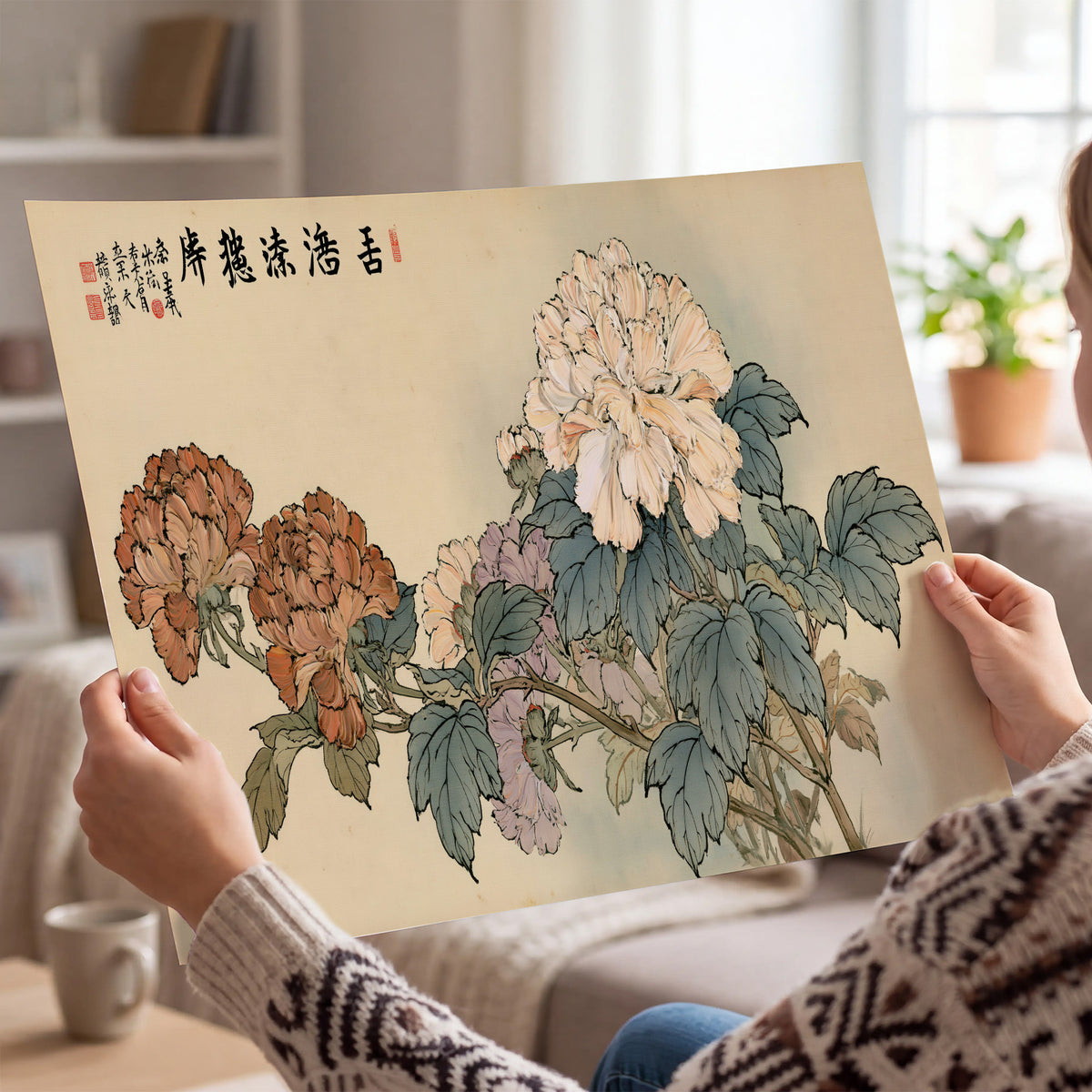 Pale pink peonies and green leaves on a warm beige background with decorative script single poster print held in hands