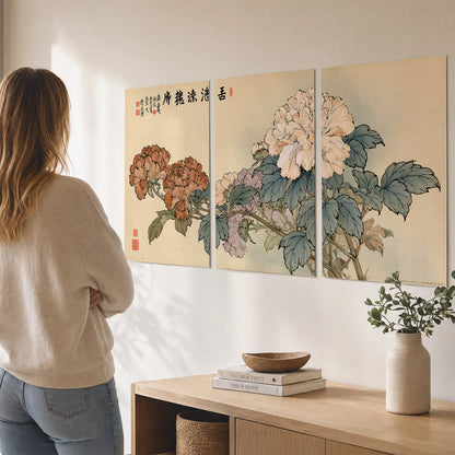 Pale pink peonies and green leaves on a warm beige background with decorative script set of 3 poster prints three panel arrangement on a wall
