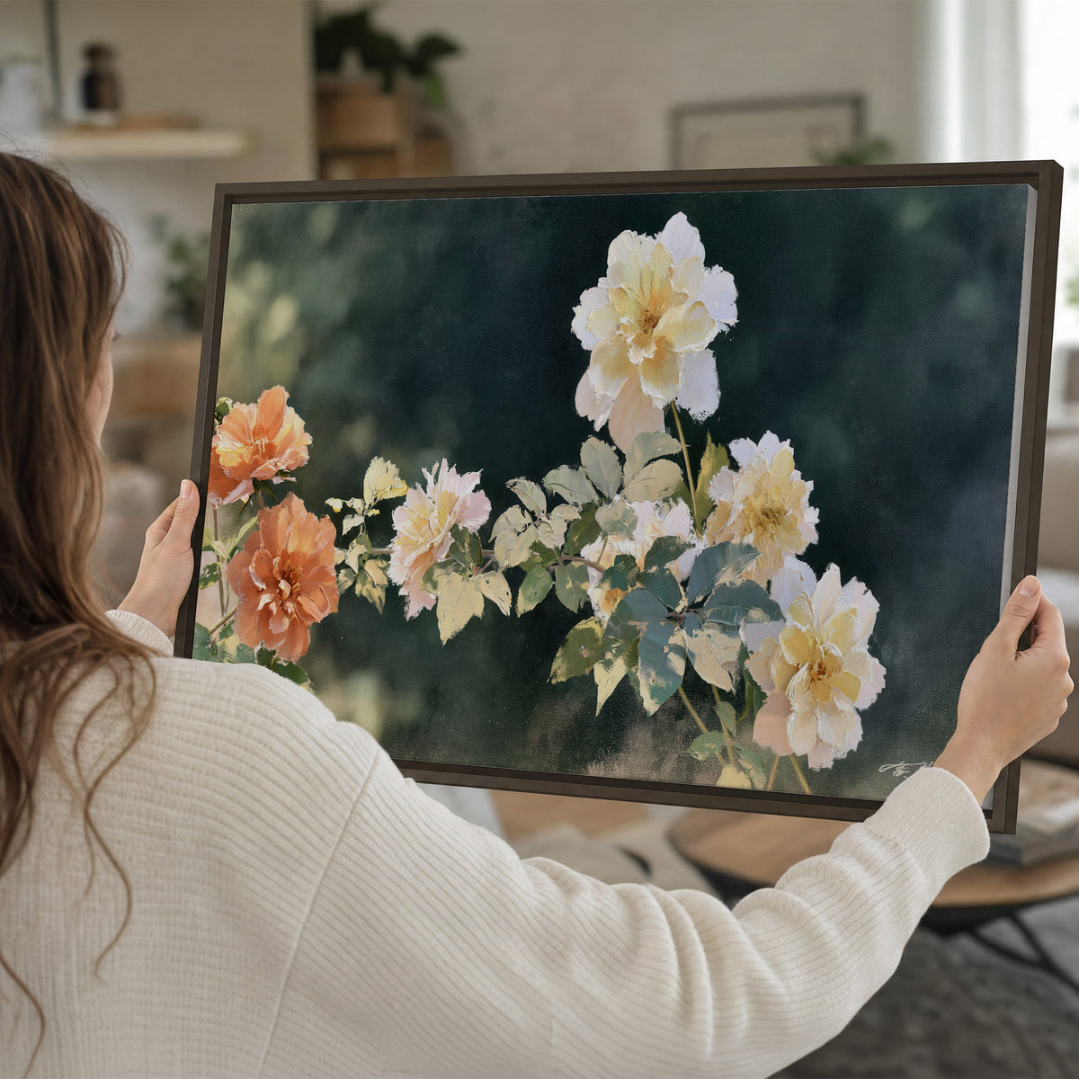White and peach roses with green leaves against a deep blue-green background single framed canvas wall art held in hands