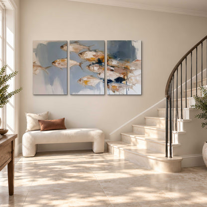 Small blue and golden fish moving across a pale layered abstract background 3 piece canvas wall art styled in an interior