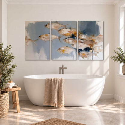 Small blue and golden fish moving across a pale layered abstract background 3 piece canvas wall art styled in an interior
